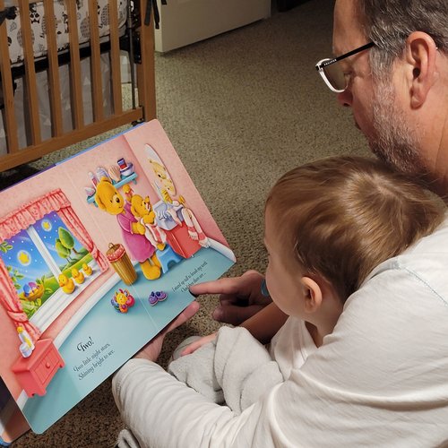 Jim Ikey reading a picture book with a grandchild